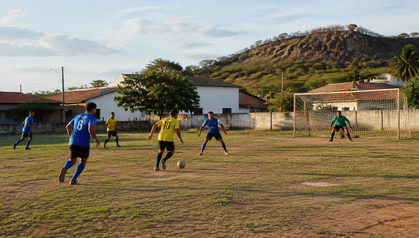 Partida de futebol amador em campo de bairro